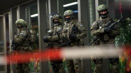 German special police stand in front of the Munich, southern Germany, main train station Thursday evening, Dec. 31, 2015 after police warned of 'imminent threat' of terror attack and ordered two train stations to be cleared. (Sven Hoppe/dpa via AP)